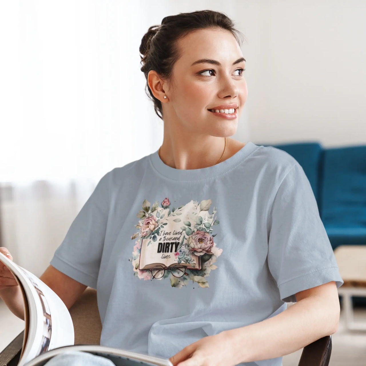 woman reading while wearing a light blue I have lived a thousand dirty lives tshirt