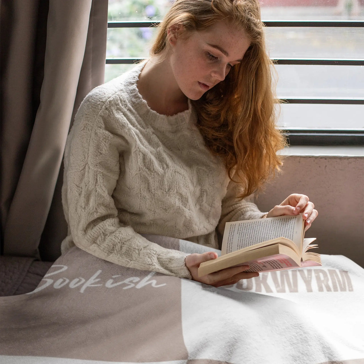 woman reading with her The bookish blanket