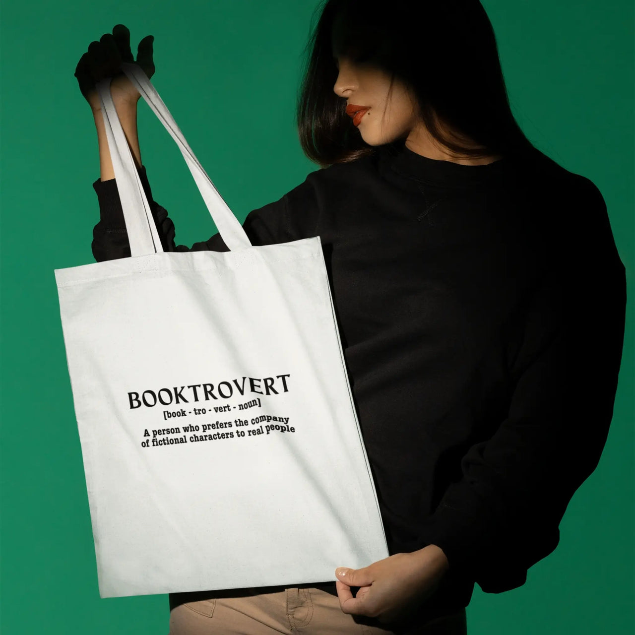 woman holding a white booktrovert tote