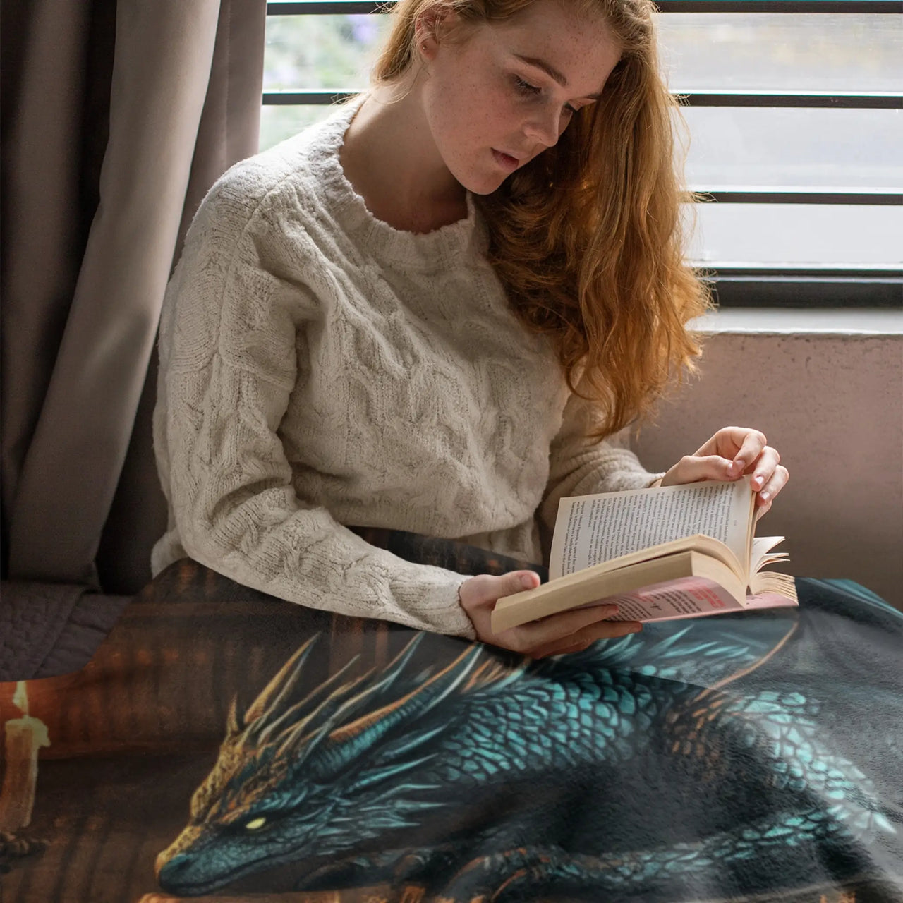 woman reading under her Bookwyrm Blanket 