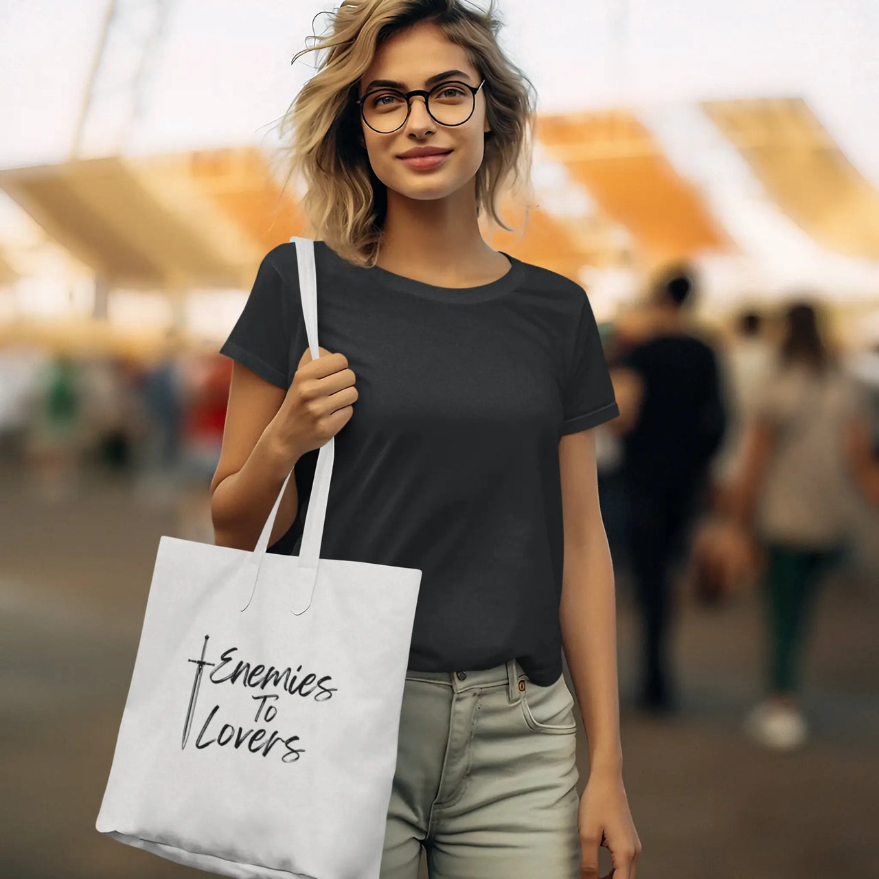 woman carrying an Enemies To Lovers tote black on white