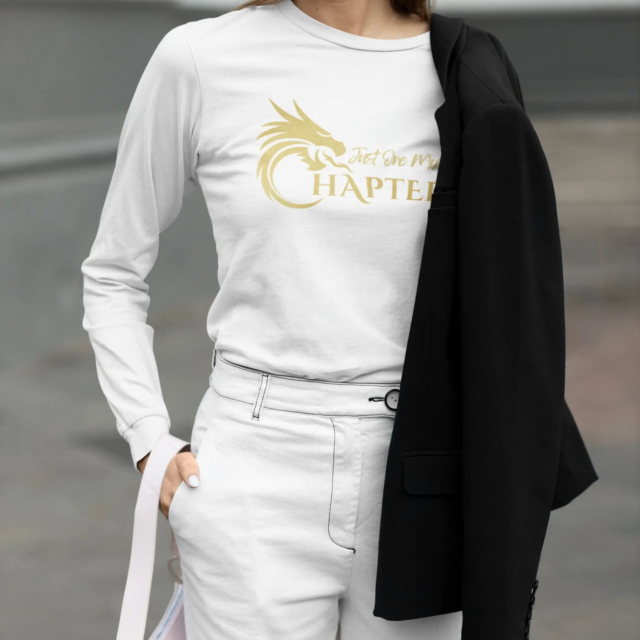 woman weraing a Just One More Chapter Logo design long sleeve in white with gold text