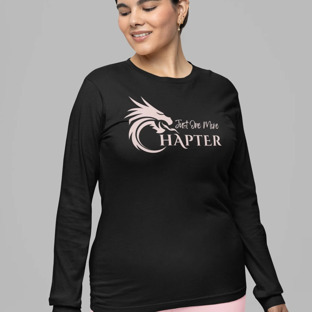 woman wearing a Just One More Chapter Logo design long sleeve in black with pink text