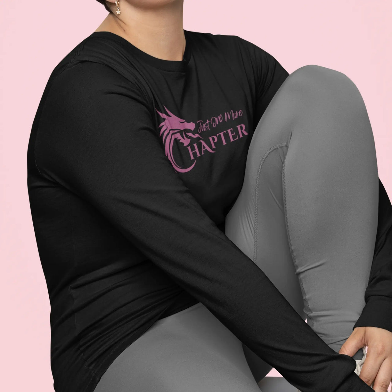 woman wearing a Just One More Chapter Logo design long sleeve in black with purple text