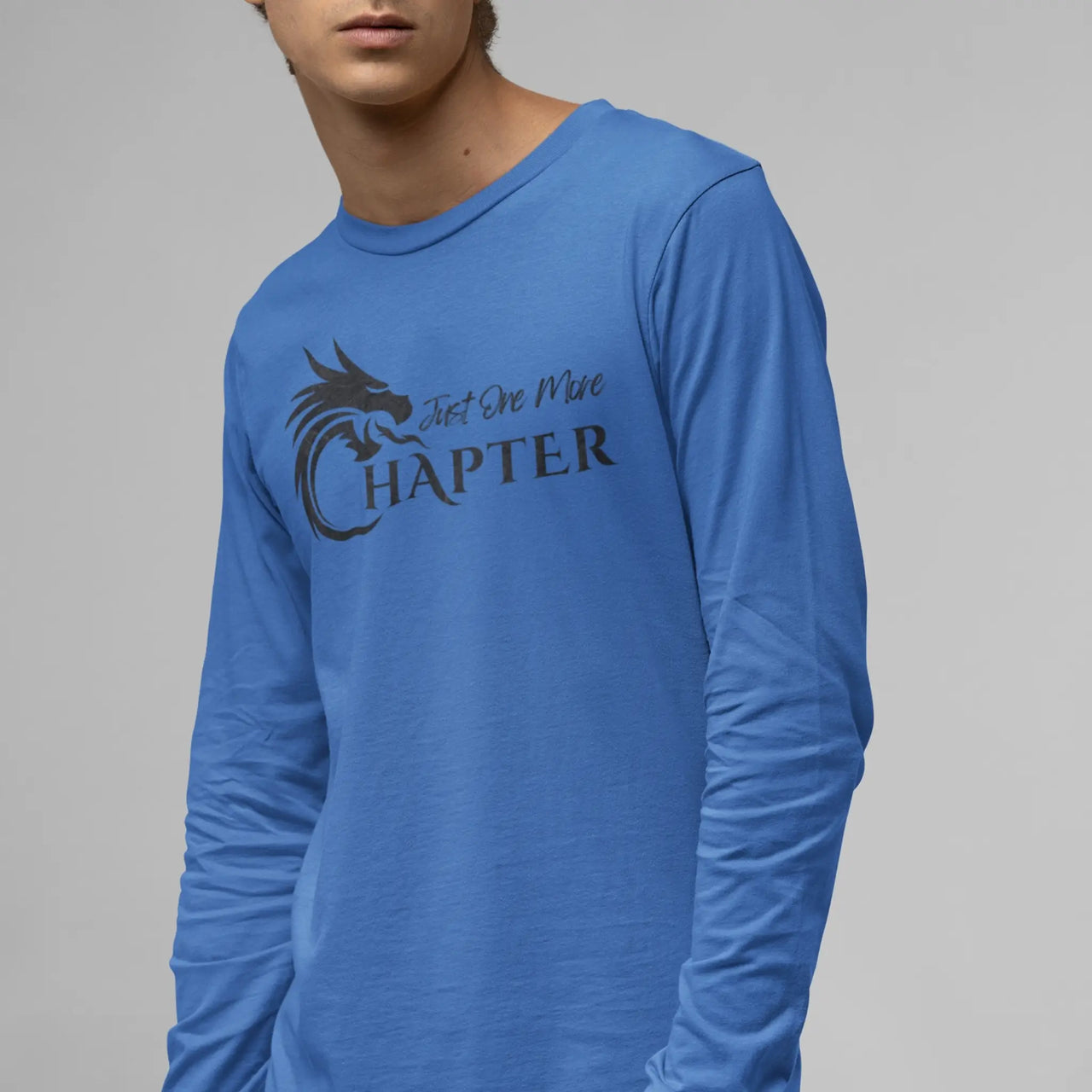 A guy wearing a Just One More Chapter Logo design long sleeve in blue with black text