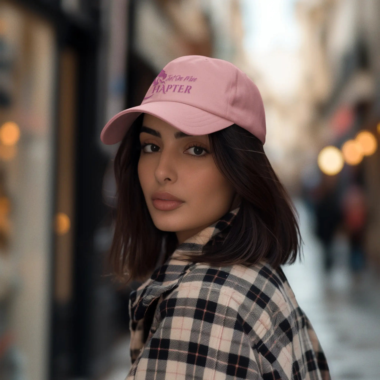 woman wearing a pink Just One More Chapter Cap