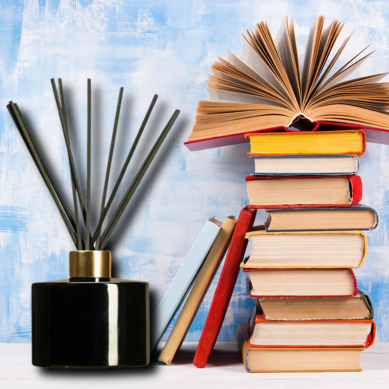 a reed diffuser beside books