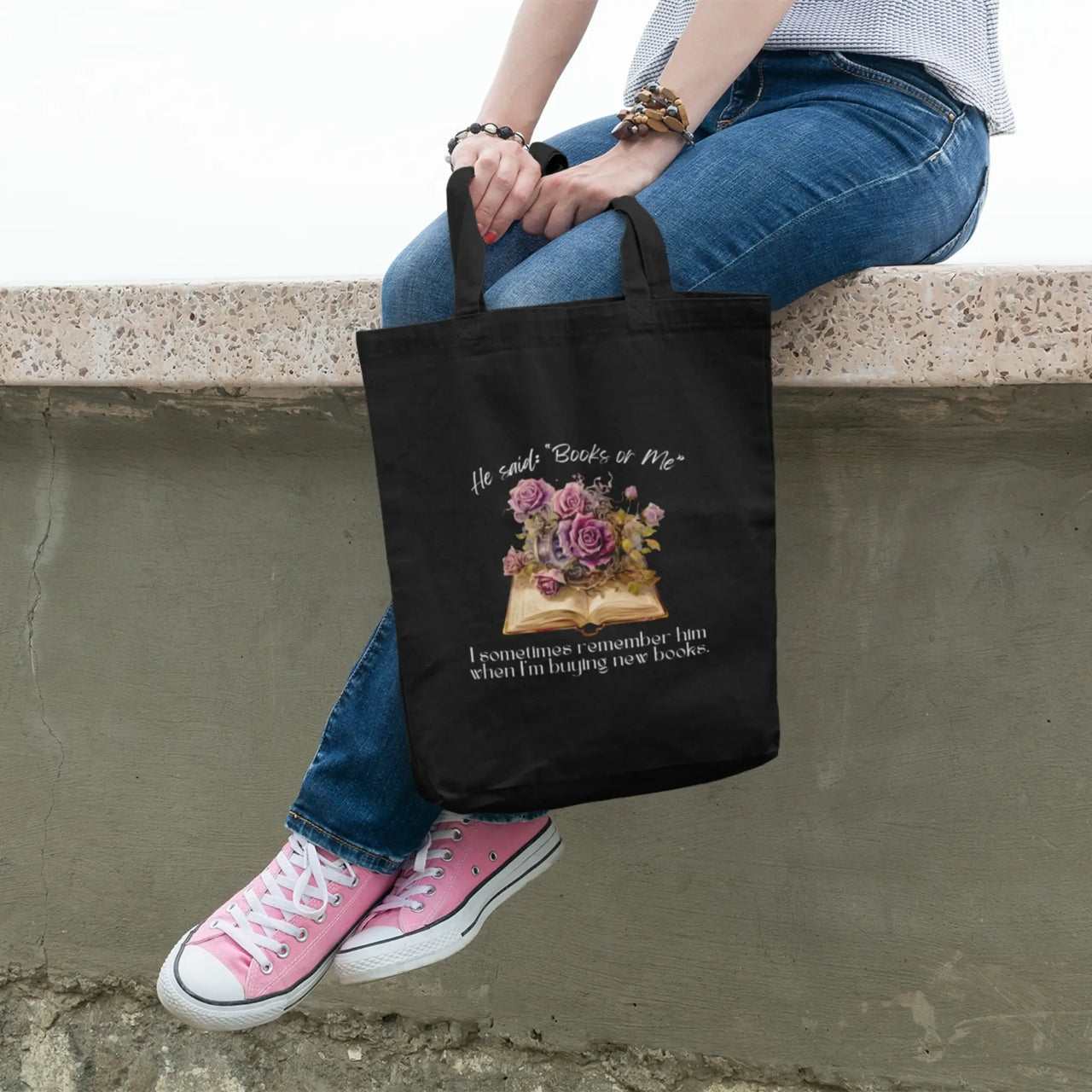 Sitting on a ledge with a Books or Me tote bag in black