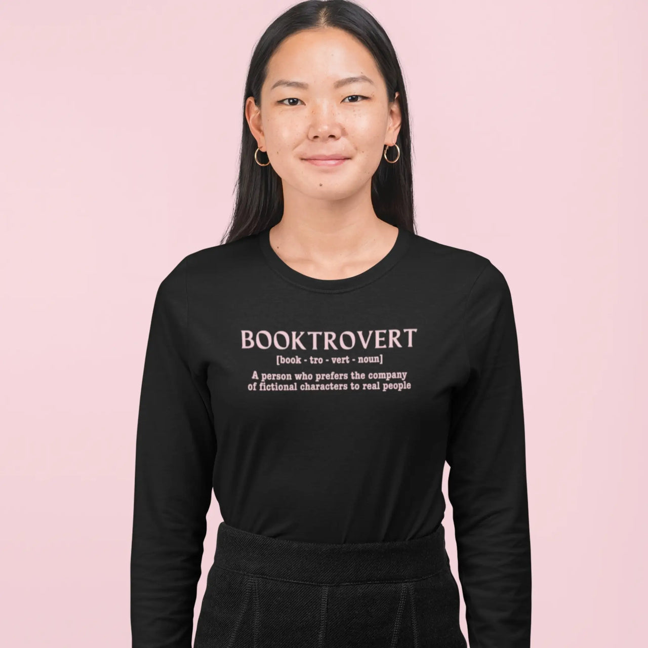 woman wearing a Booktrovert long sleeve tshirt in black with pink text