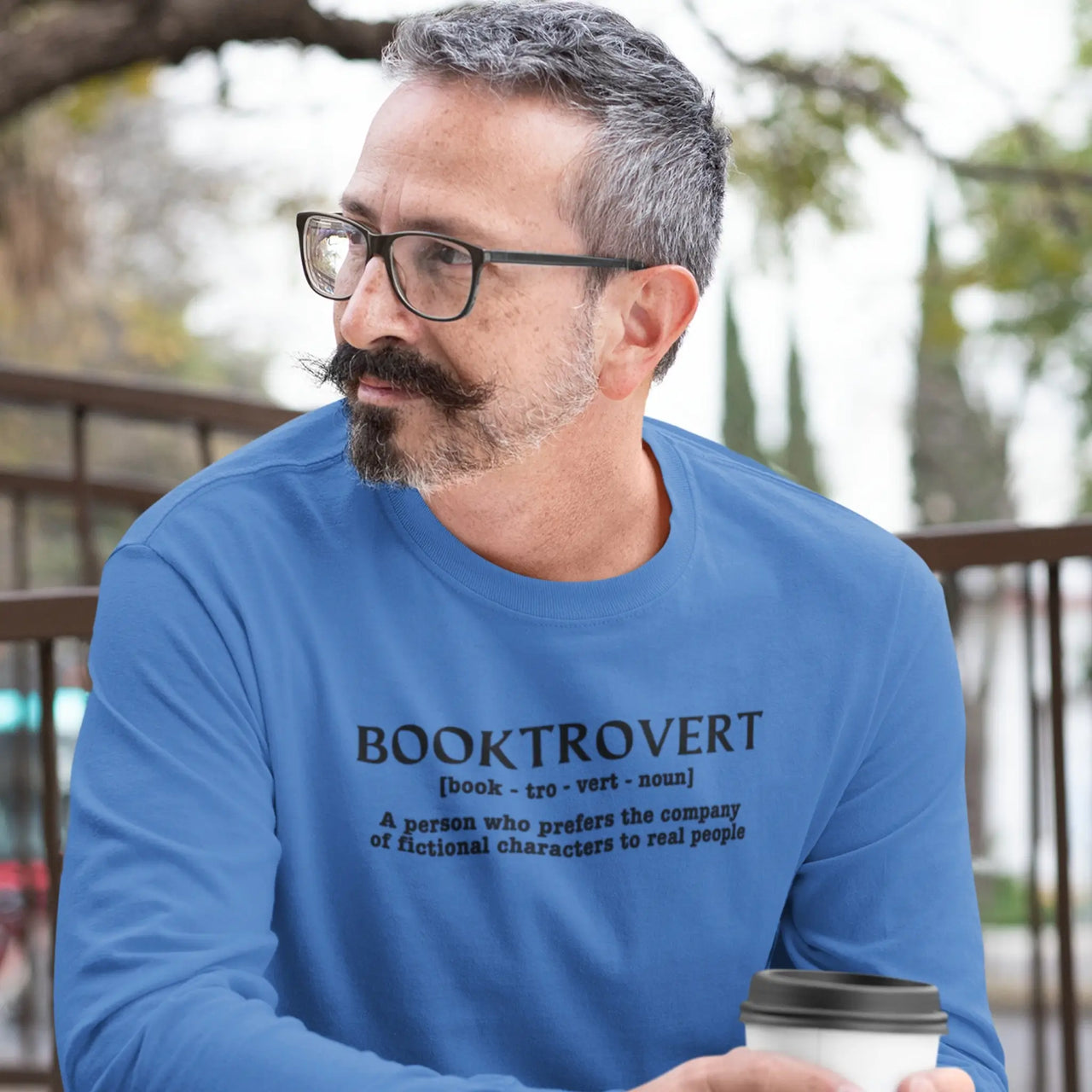 a guy wearing a Booktrovert long sleeve tshirt in blue with black writing