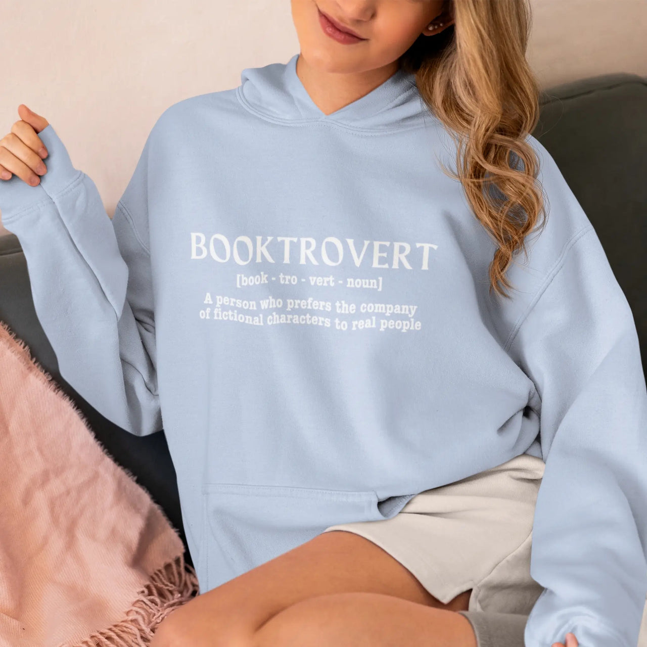 young woman wearing a booktrovert hoodie with white text