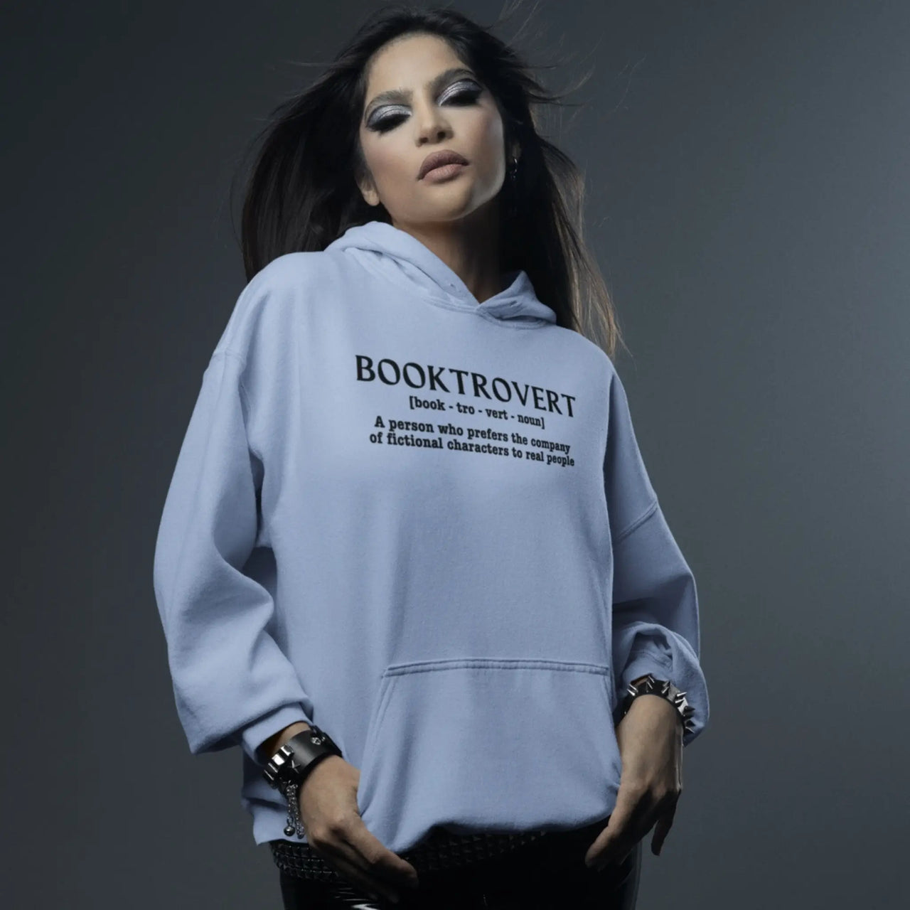 woman wearing a light blue Booktrovert Hoodie with white text