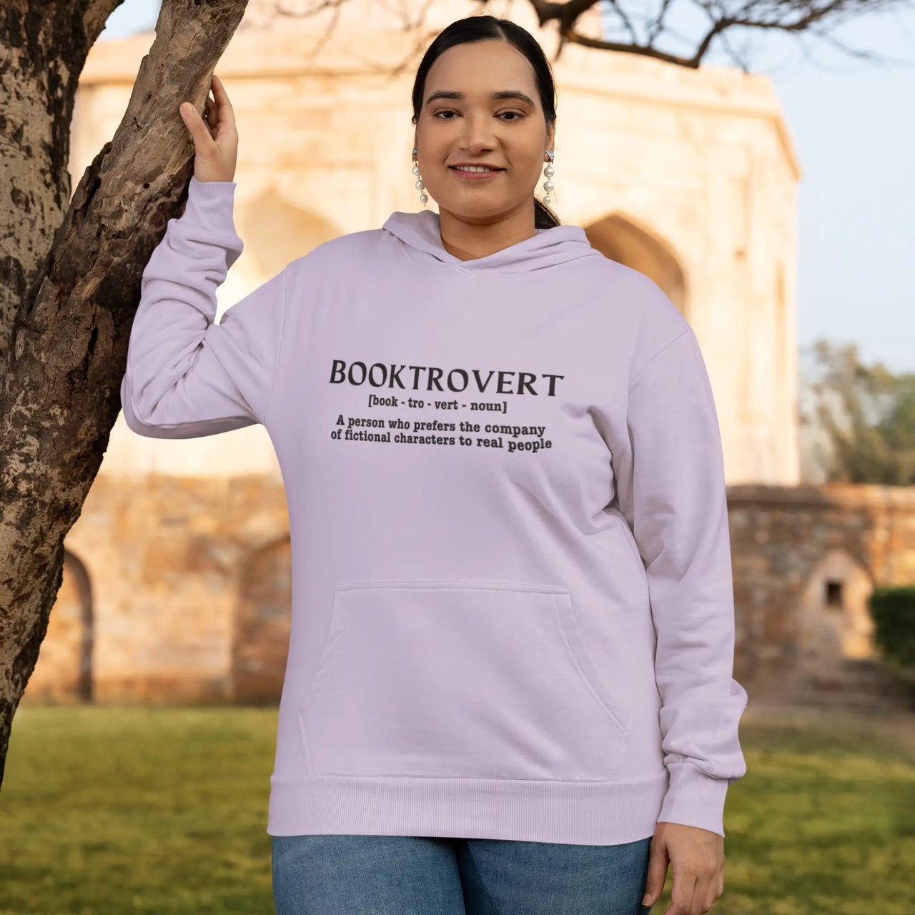 woman wearing an orchid booktrovert hoodie with black text outside