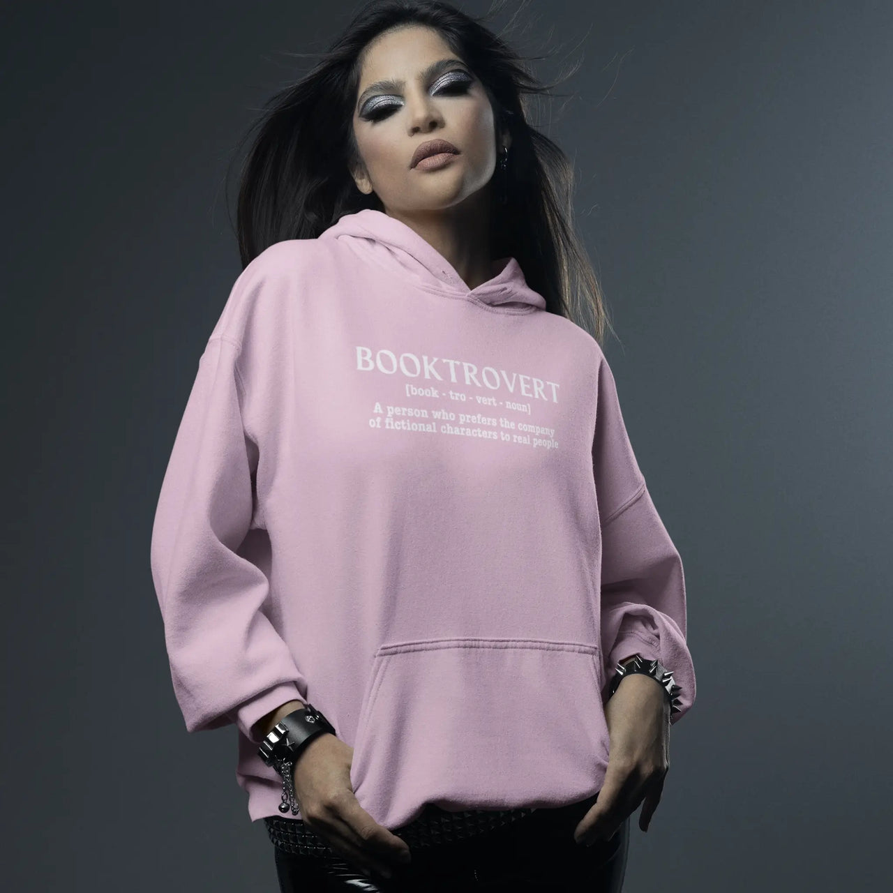 woman wearing a Pink Booktrovert Hoodie with white text