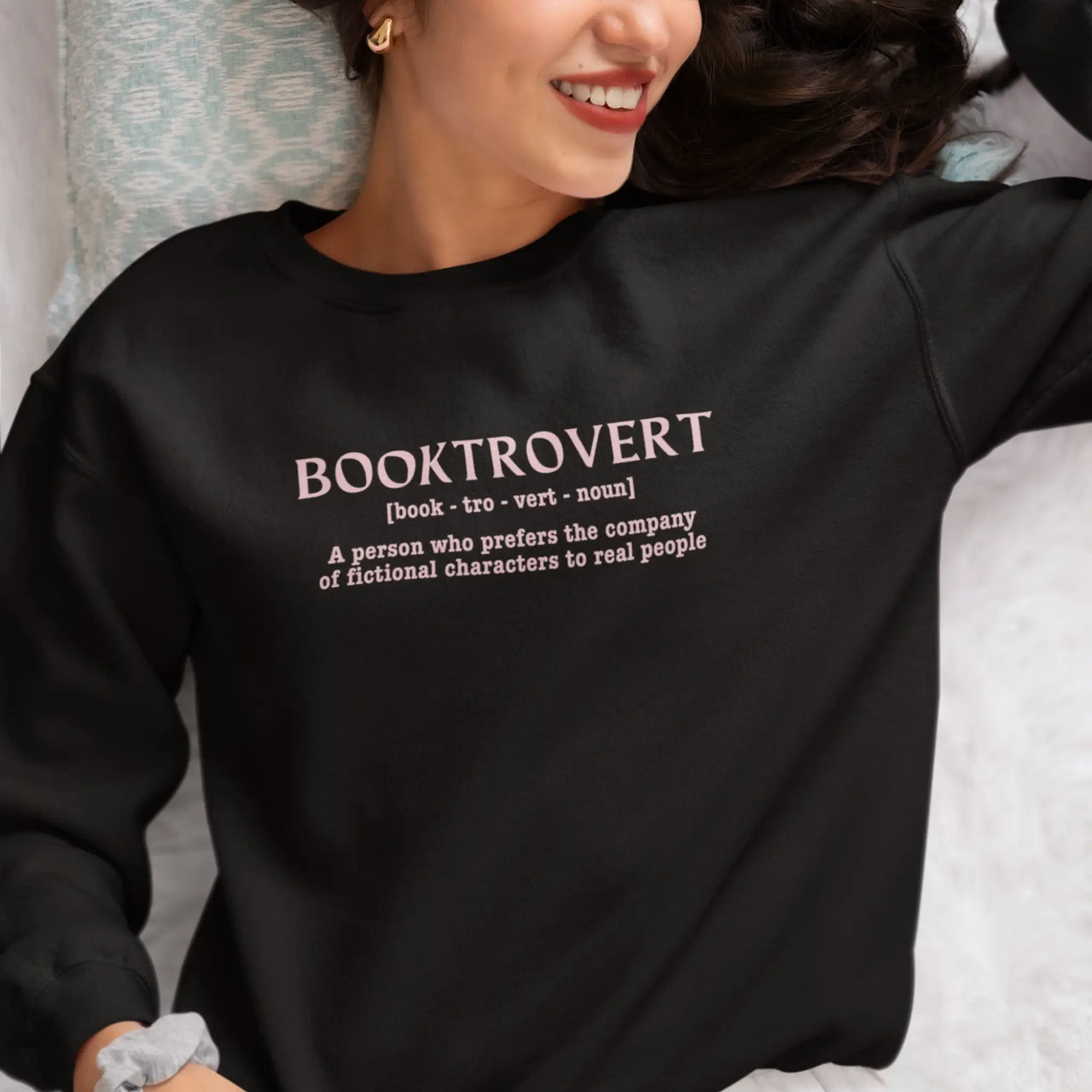 woman wearing a black Booktrovert Sweatshirt pink text