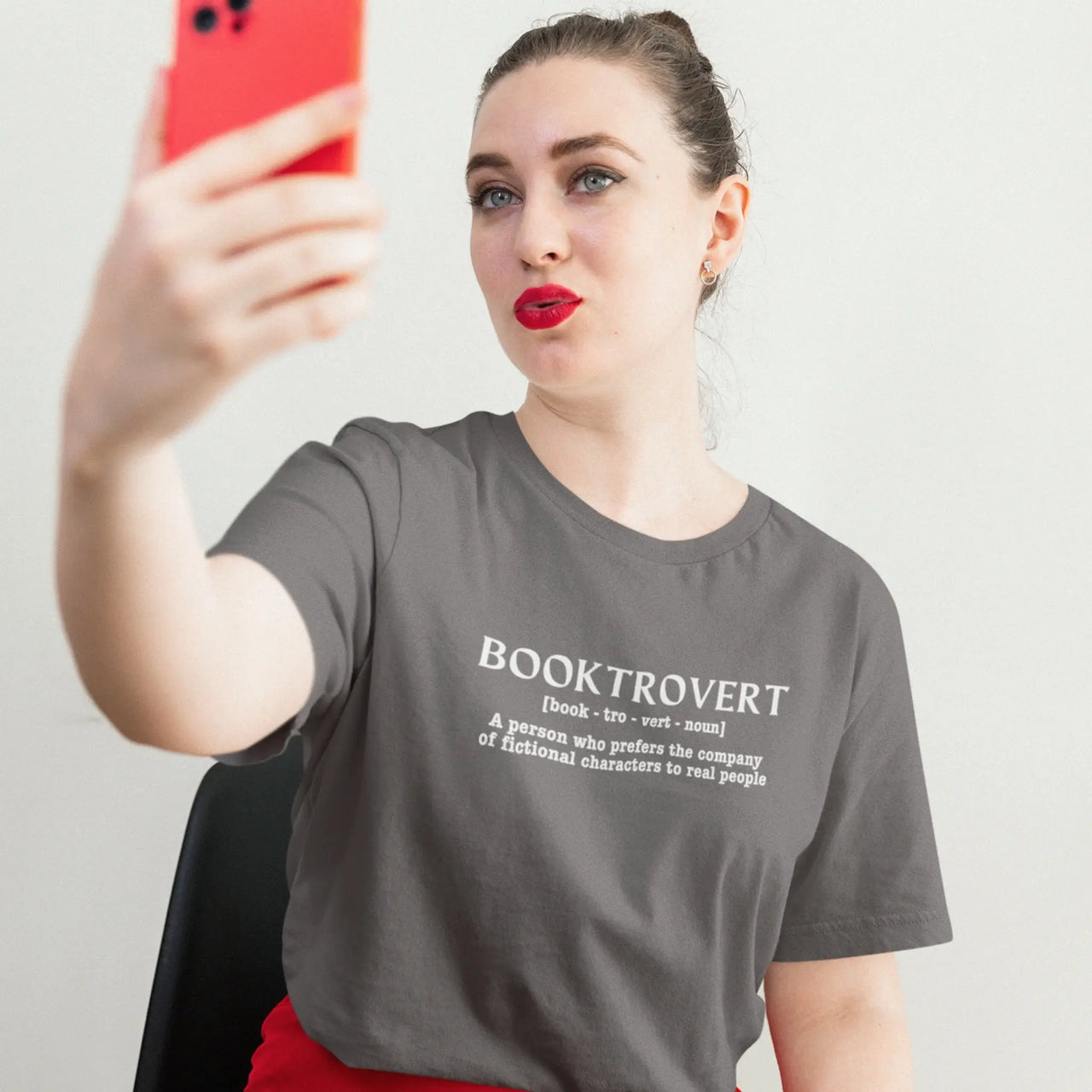 woman wearing a dark grey booktrovert tshirt with white text