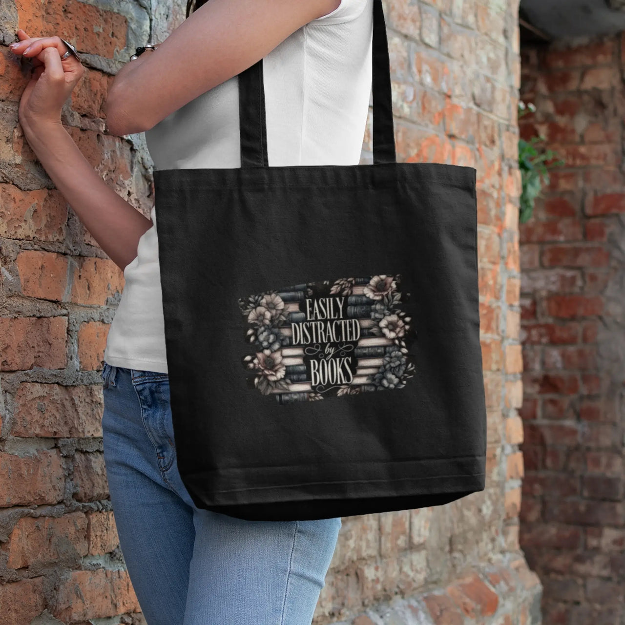 Easily Distracted By books tote bag in black over a woman's shoulder