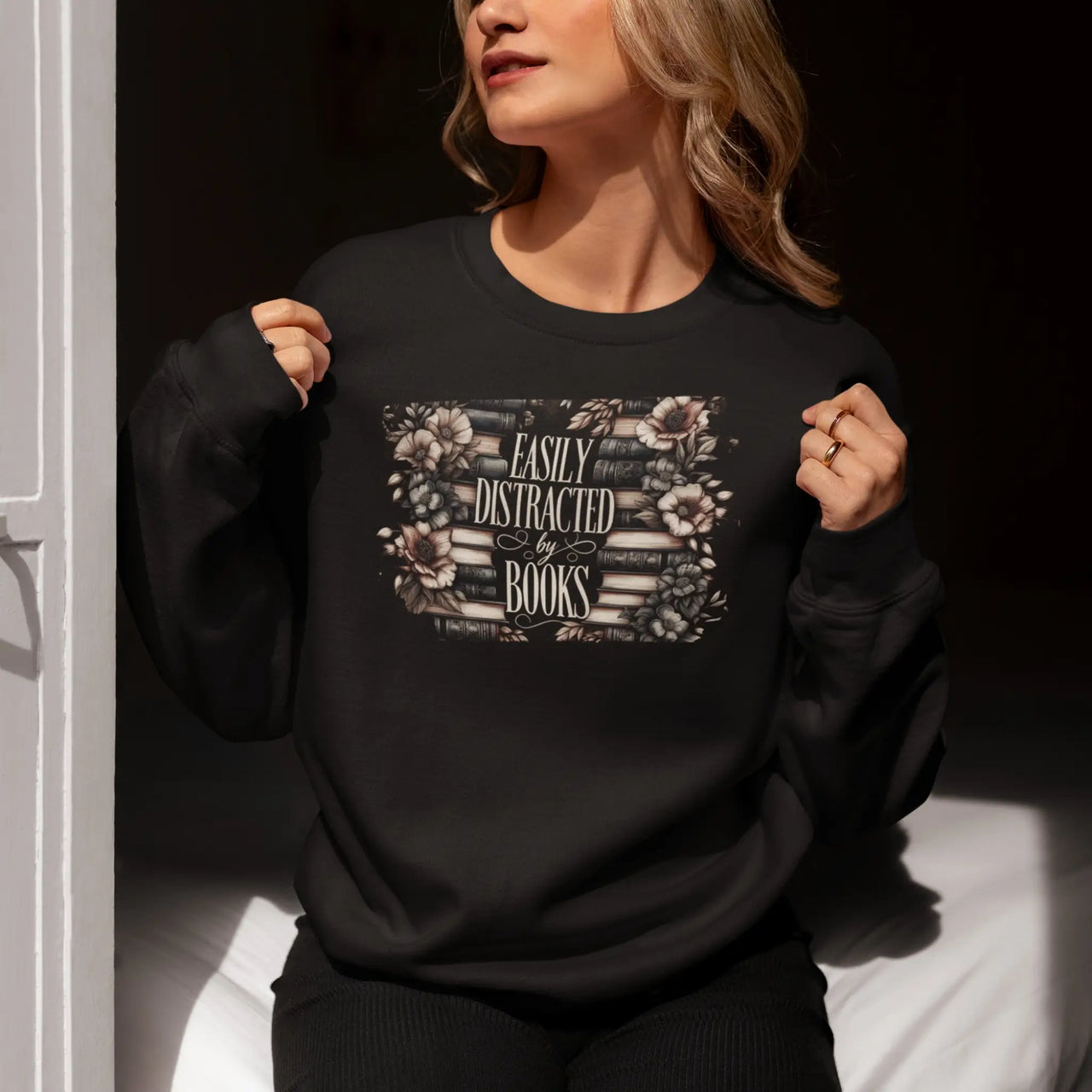 woman wearing a black Easily Distracted By Books Sweatshirt