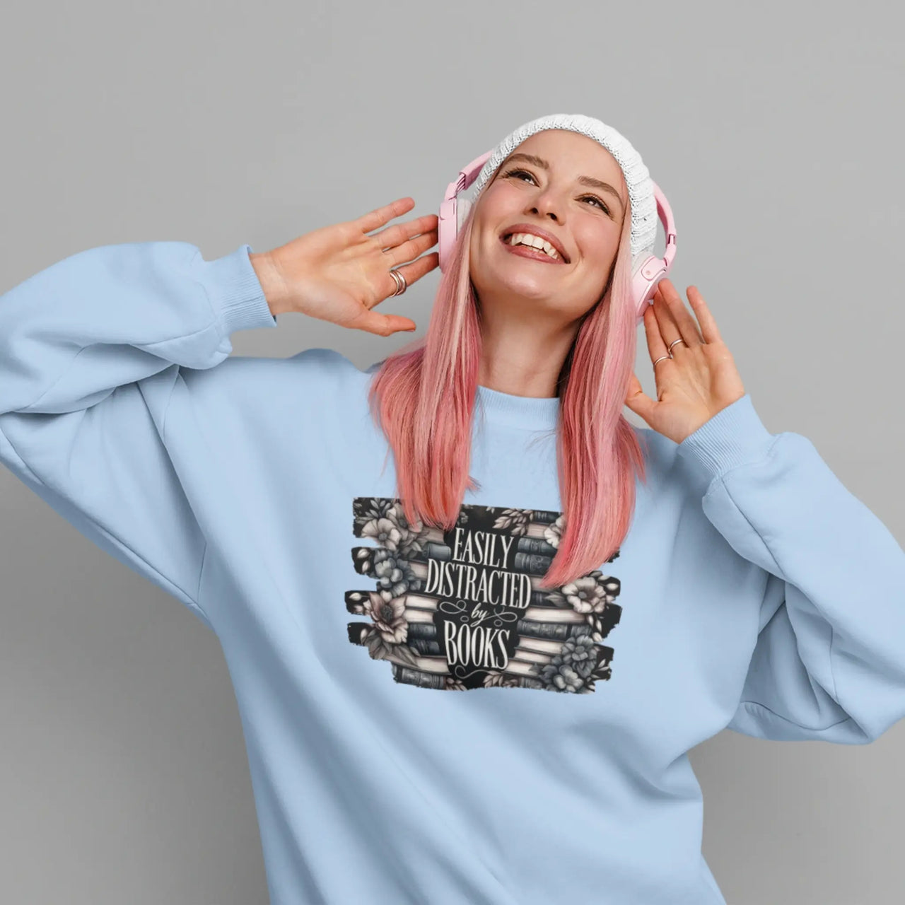 woman wearing the blue Easily Distracted By Books Sweatshirt