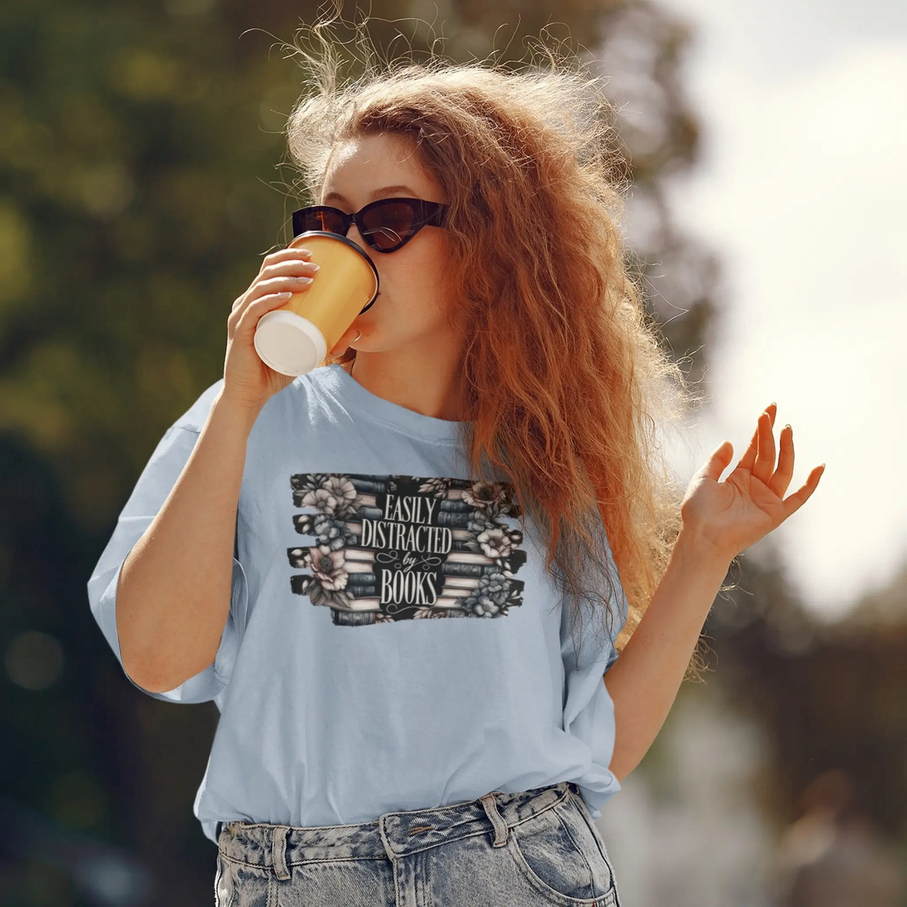 Woman drinking coffee wearing a Light blue Easily distracted by books tshirt