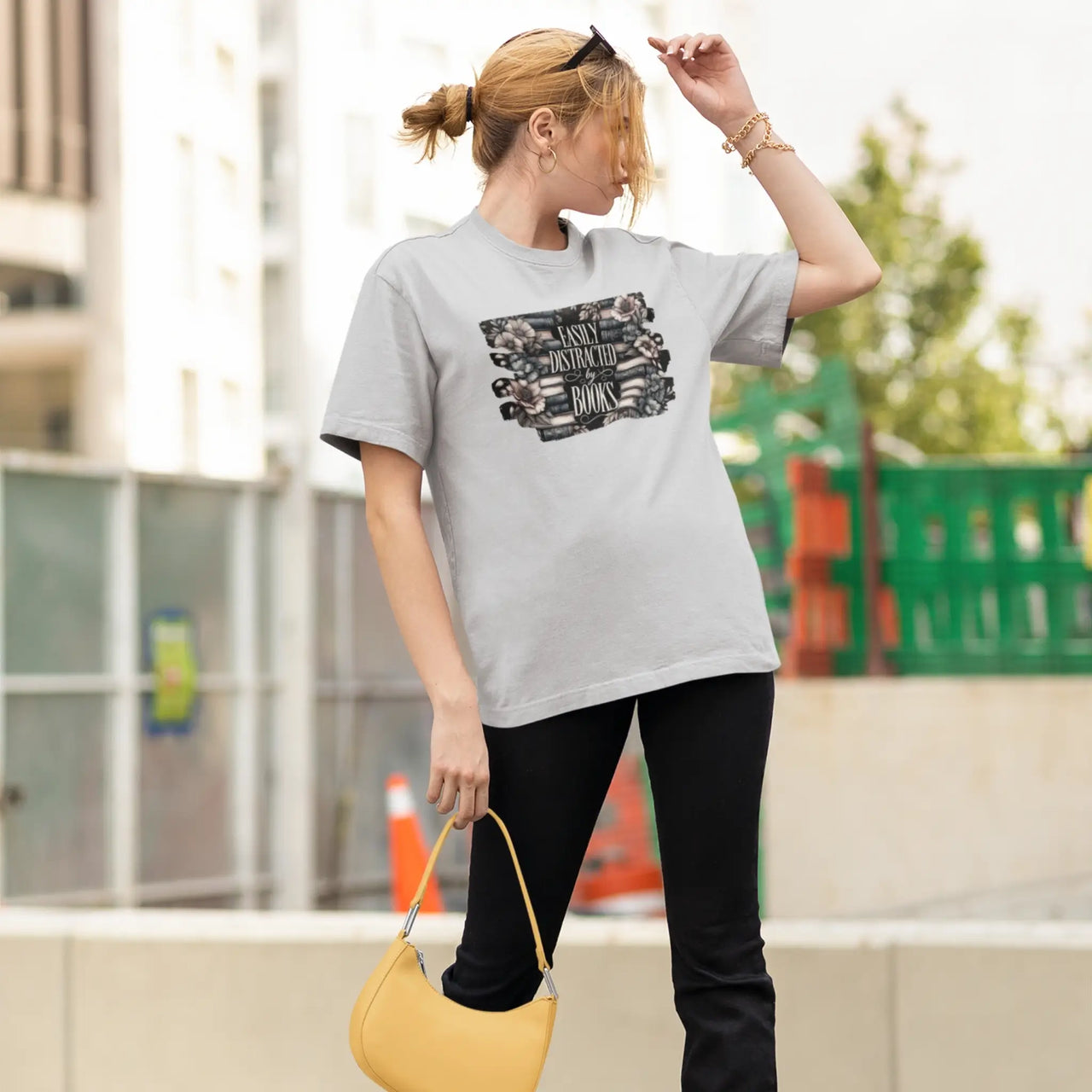 holding a purse while wearing a Light grey Easily distracted by books tshirt