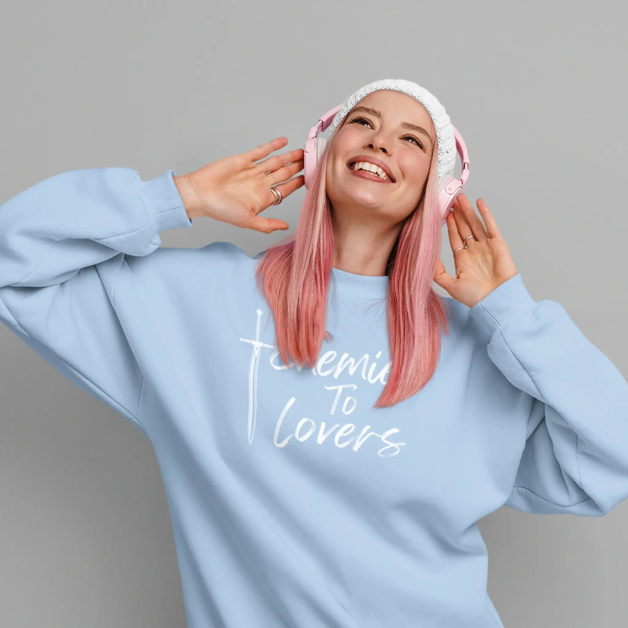 young woman wearing a blue Enemies To Lovers sweatshirt with white text