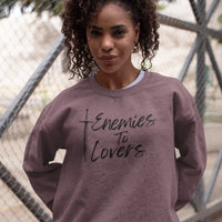 Thumbnail for woman wearing the heather maroon Enemies To Lovers sweatshirt with black text