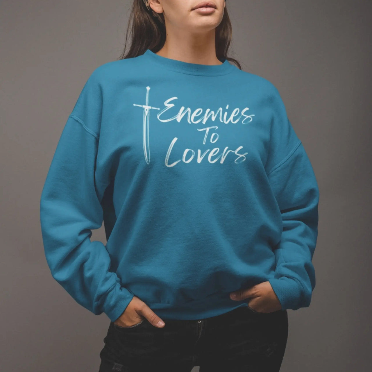 woman wearing teal Enemies To Lovers sweatshirt with white text