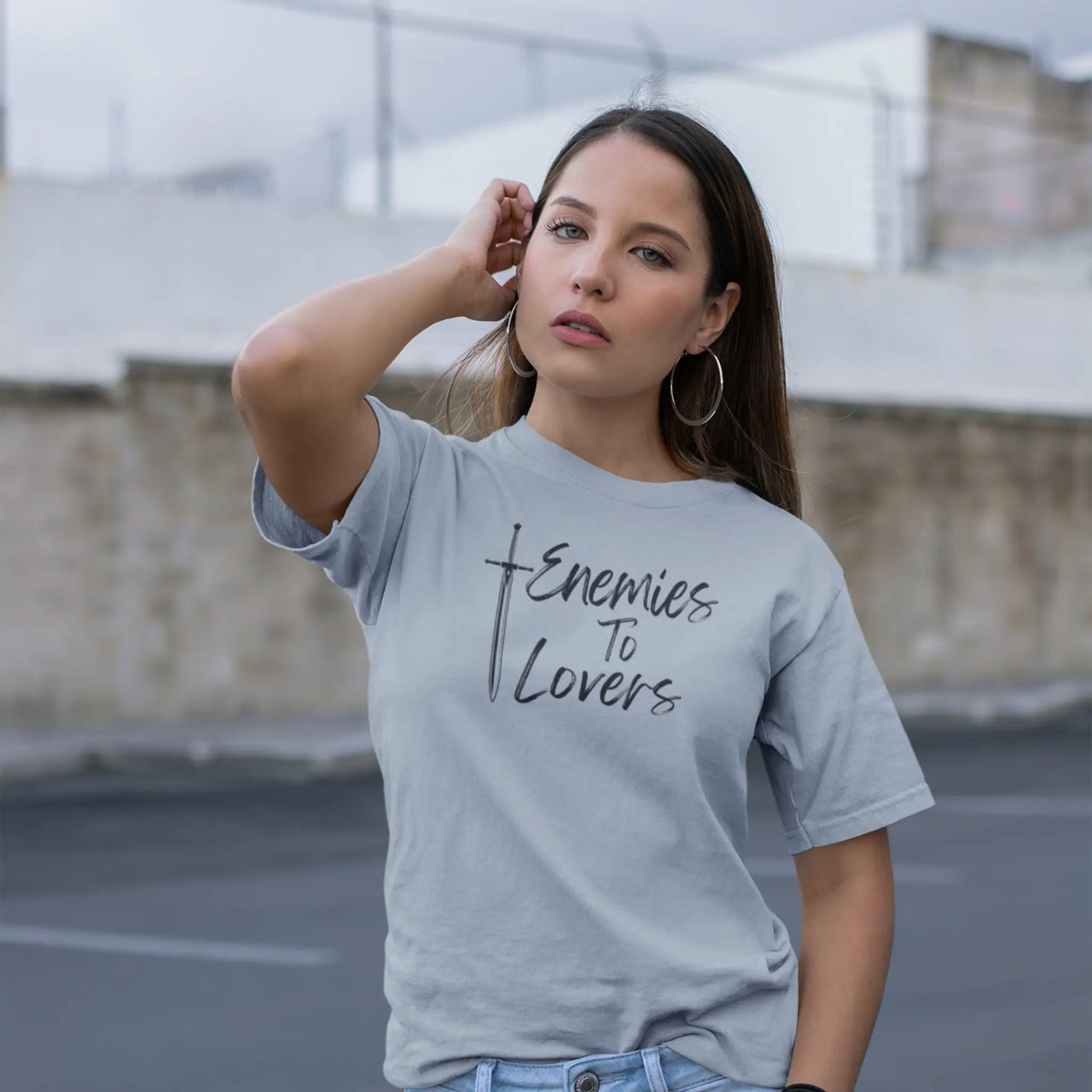 posing in a light blue Enemies To Lovers Tshirt