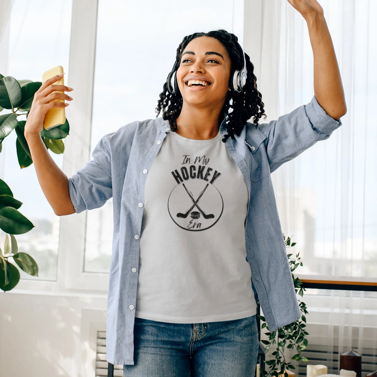 woman celebrating wearing a light grey in my hockey era tshirt