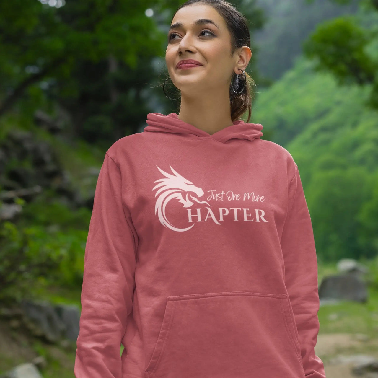 a smiling woman wearing a dark pink Just One More Chapter Hoodie V1 with pink text