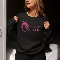 Thumbnail for woman wearing a black Just One More Chapter sweatshirt with purple text