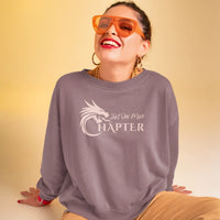 Thumbnail for woman with sunglasses wearing a maroon Just One More Chapter sweatshirt with pink text