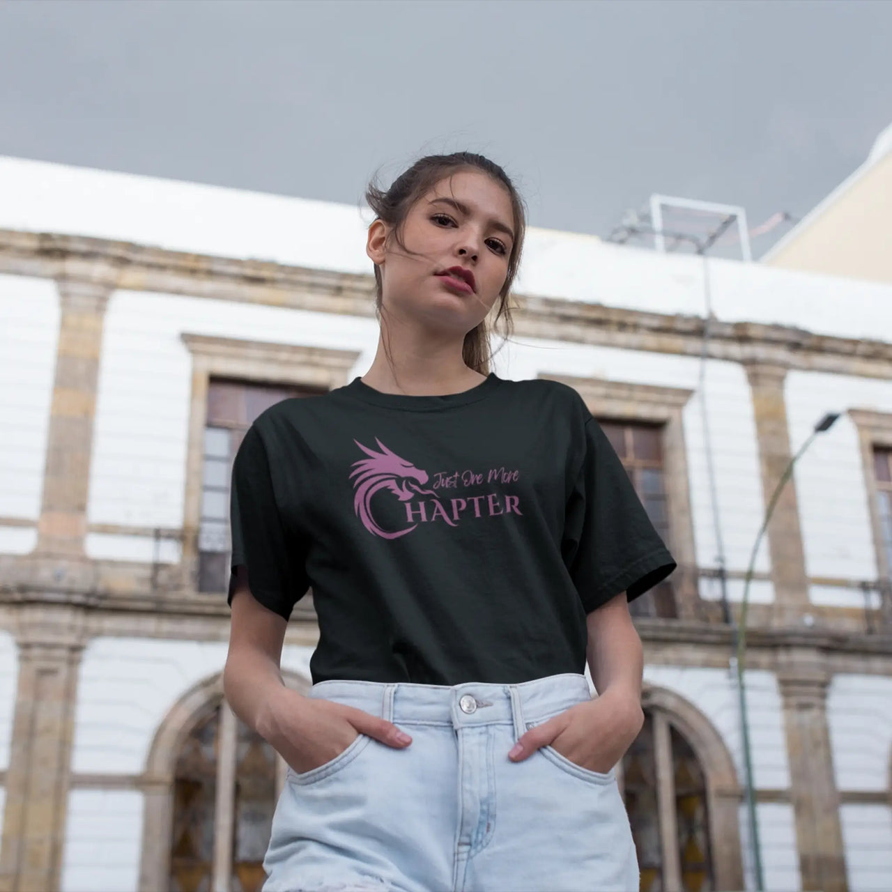 woman posing with a black Just one more chapter tshirt with purple text