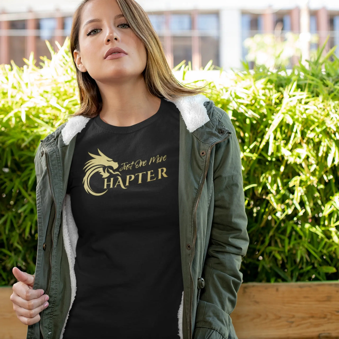 woman wearing a black Just one more chapter tshirt with gold text