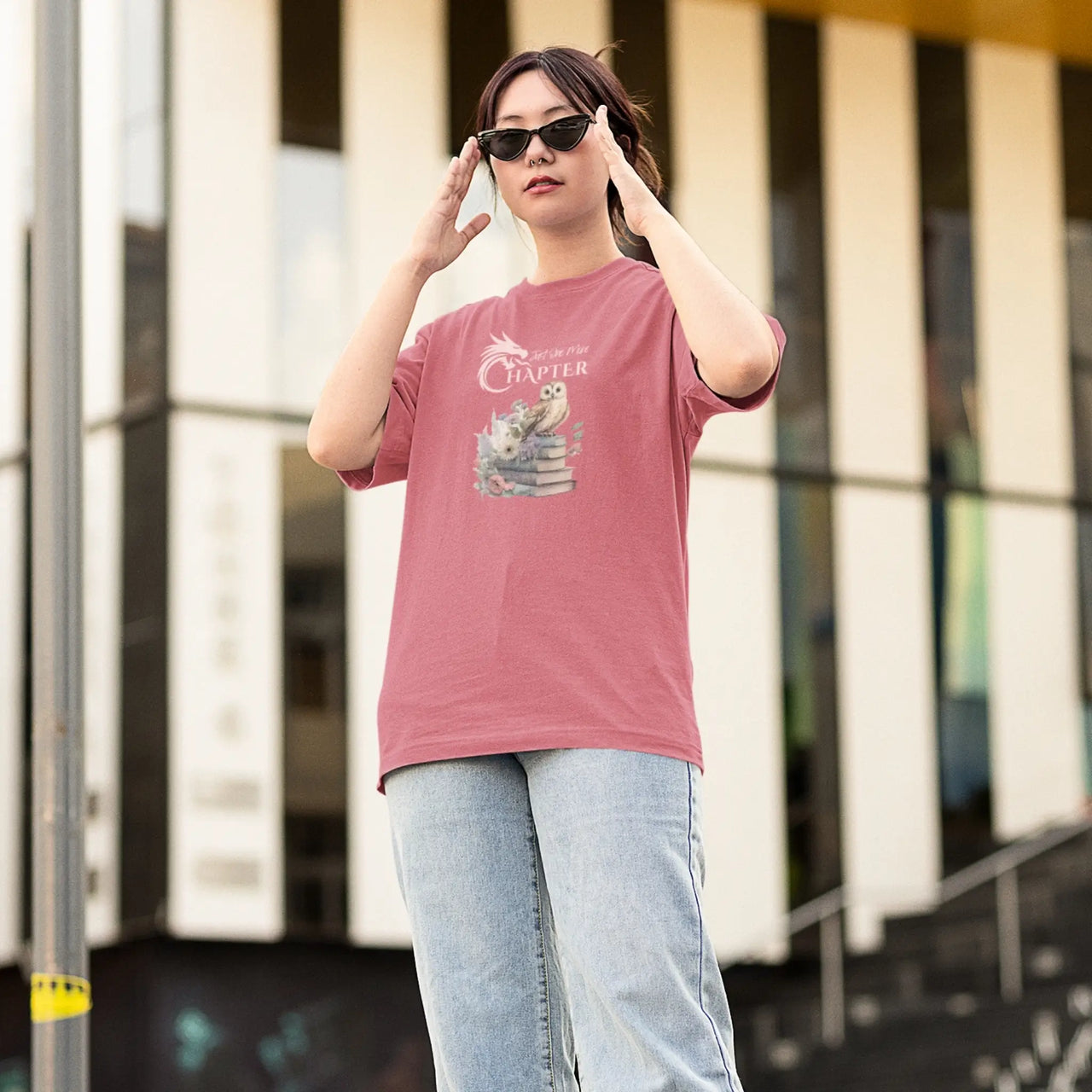 woman wearing sunglasses posing in a Dark pink Just One More Chapter T-shirt V3 with pink text