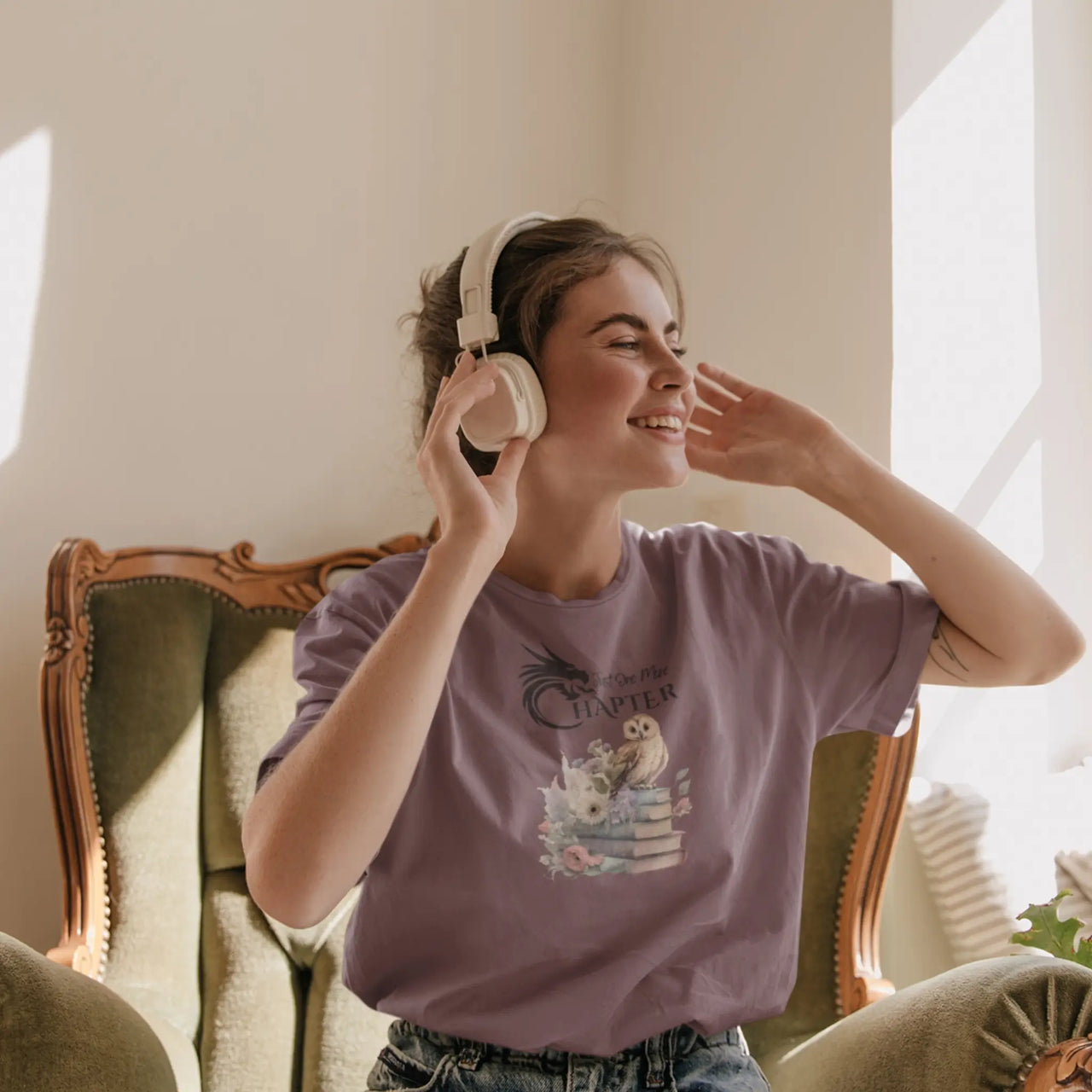 woman in headphones wearing a Maroon Just One More Chapter T-shirt V3 with black text