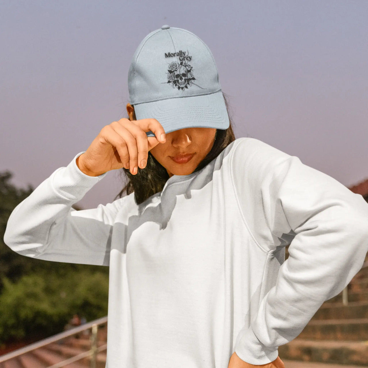 an avid reader wearing a light blue Morally Grey cap