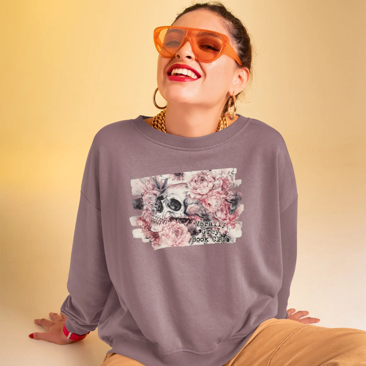 smiling woman in sunglasses posing in a young woman wearing the maroon morally grey sweatshirt V2