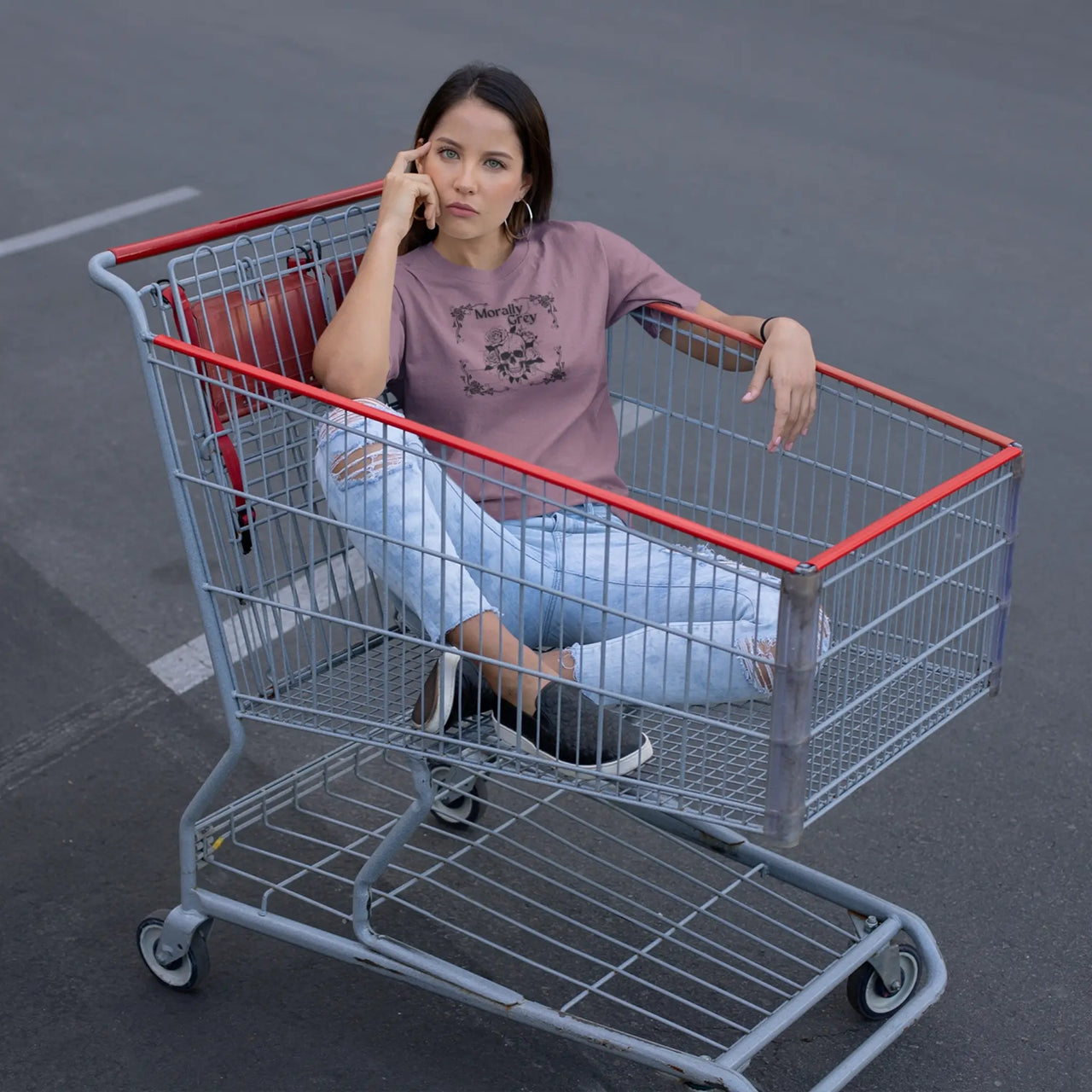 woman sitting in a cart wearing a maroon morally grey tshirt