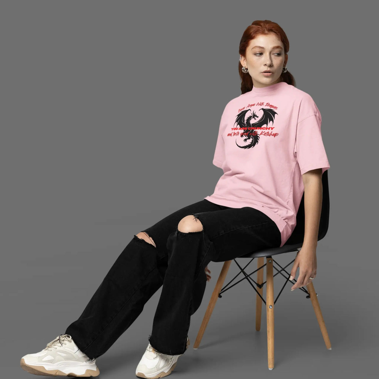 sitting in a chair wearing a Light pink Never Argue With Dragons Tshirt