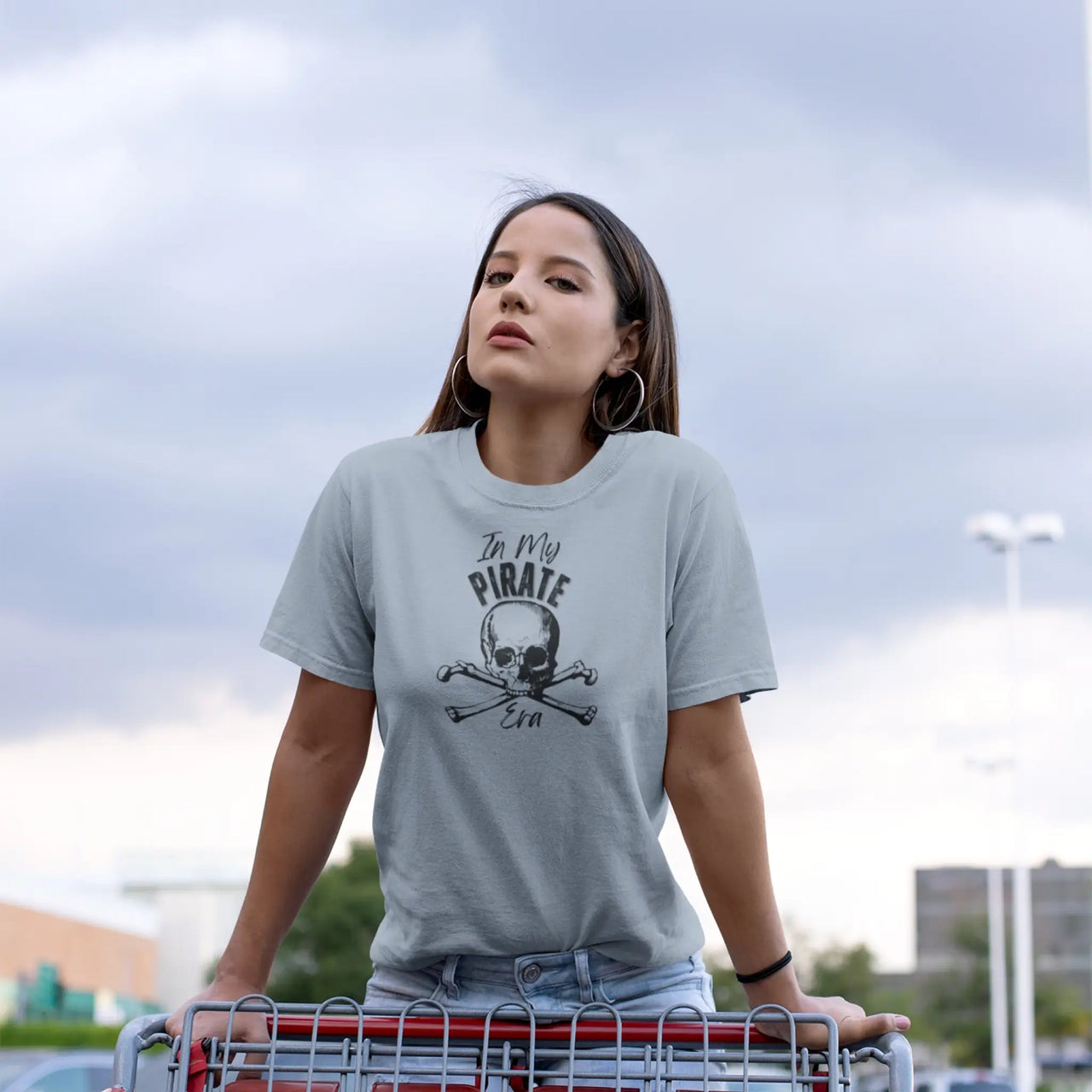 woman pushing a shopping cart wearing a light blue in my pirate era tee 