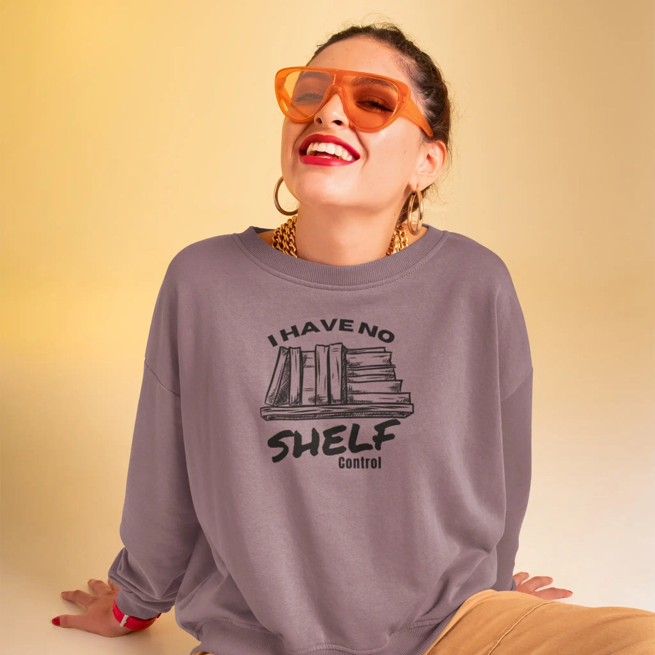 Woman in sunglasses posing with a Maroon I have no shelf control sweatshirt