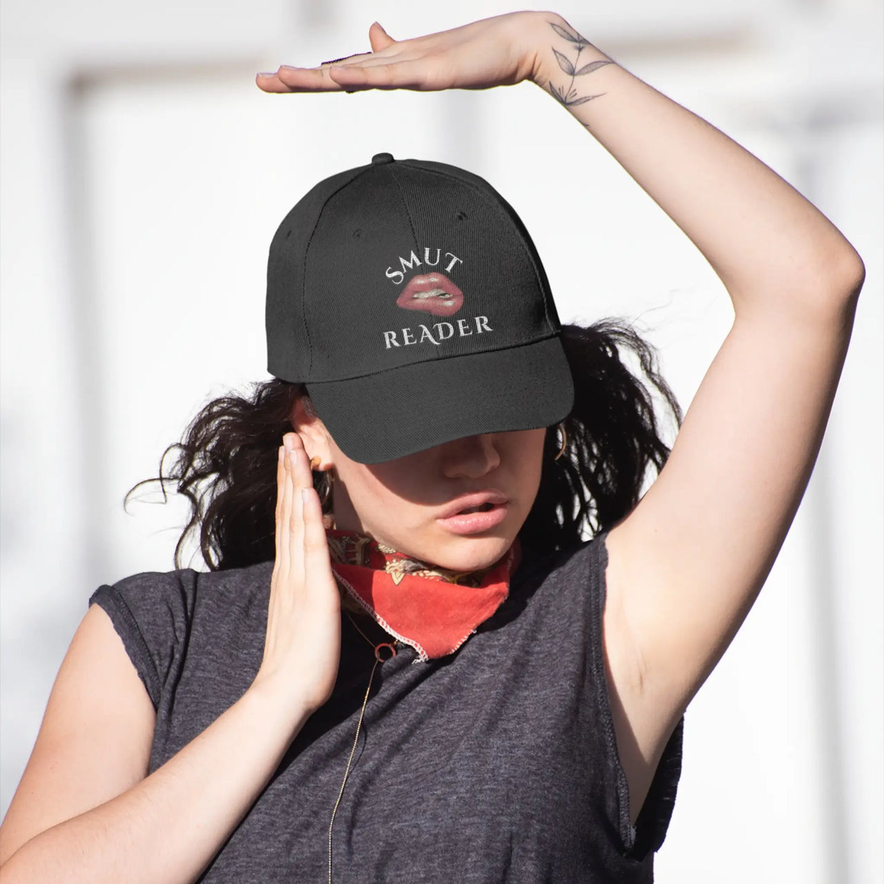 woman wearing a black smut reader cap with biting lip