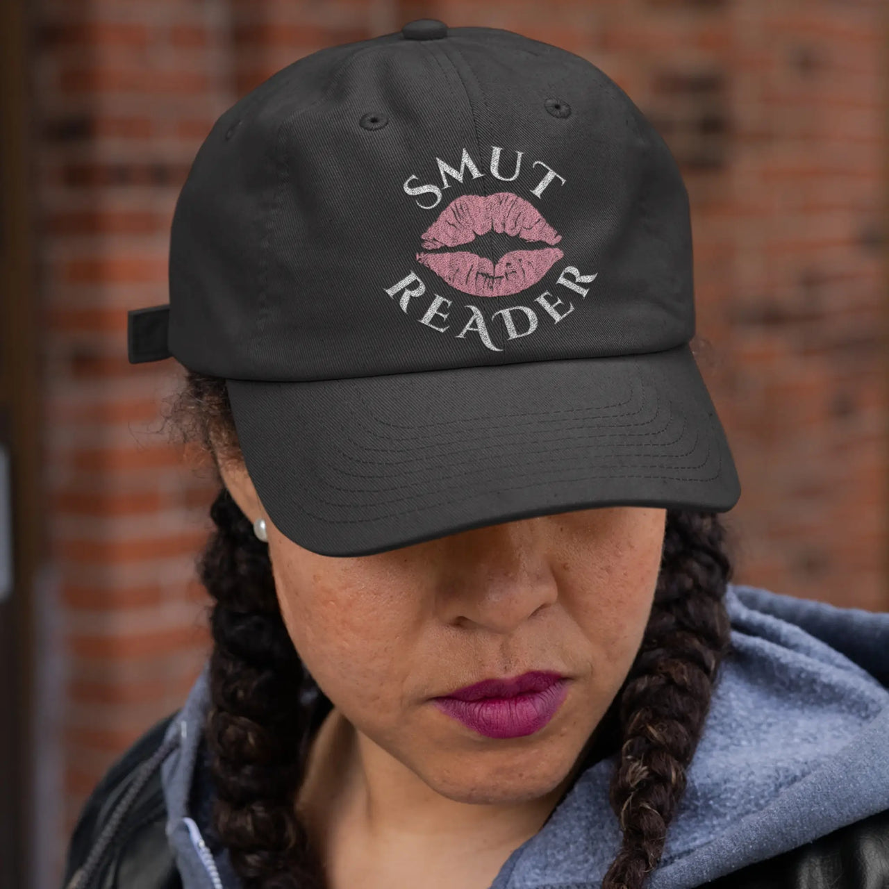 woman wearing a black smut reader cap with pink lips