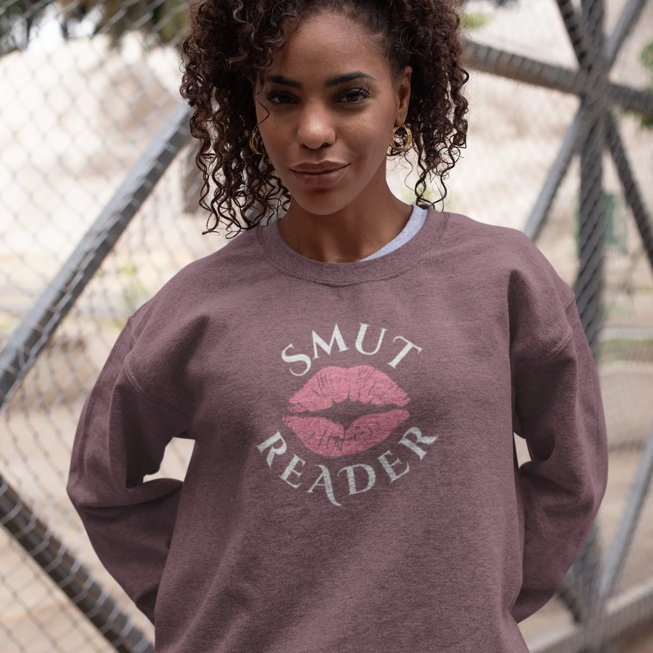 woman wearing a heather maroon smut reader sweatshirt pink lips