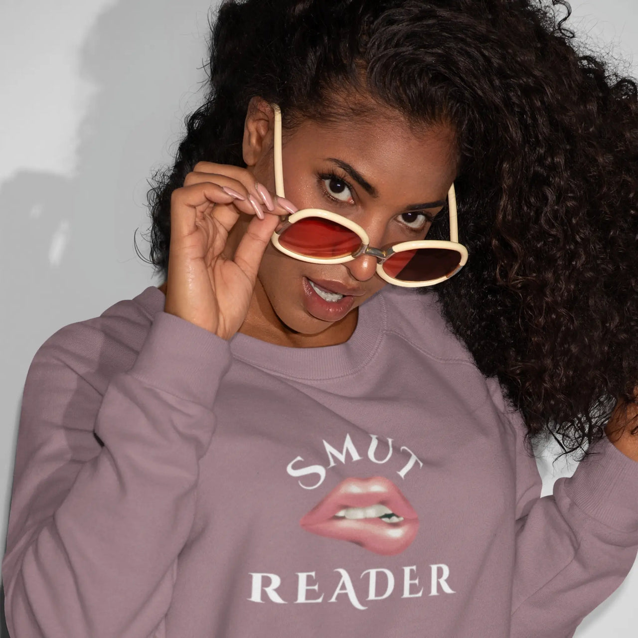 woman wearing a maroon smut reader sweatshirt v2 white text