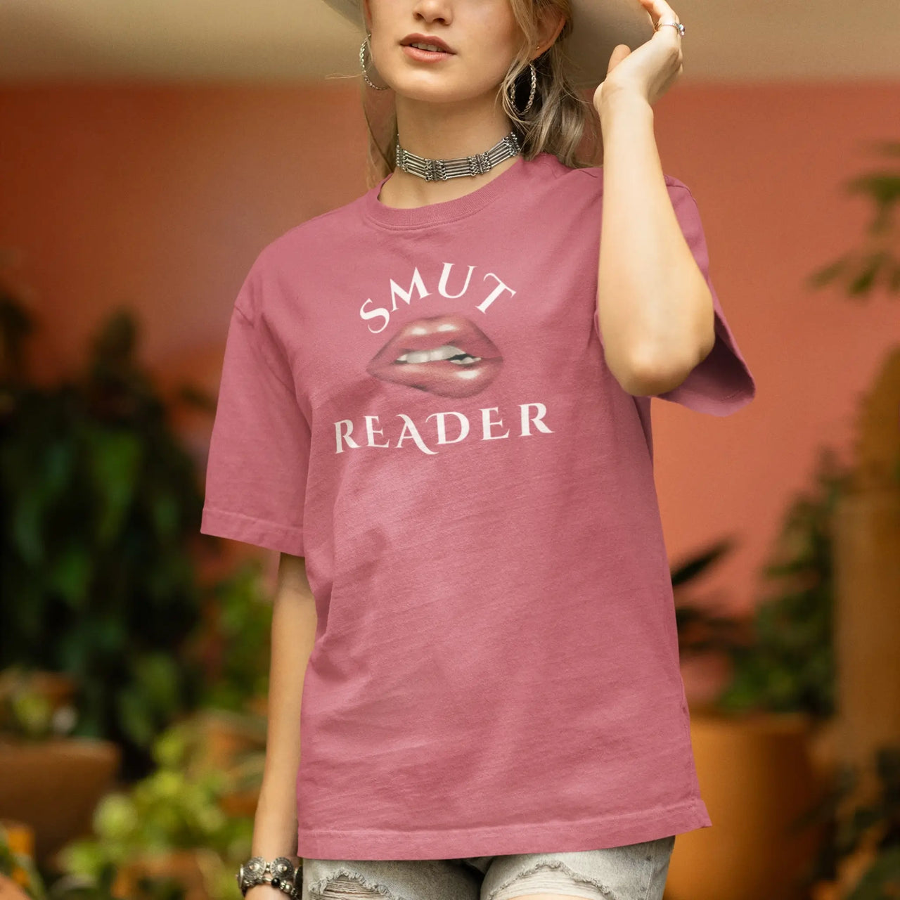 woman wearing heather dark pink smut reader v3 tshirt with white writing